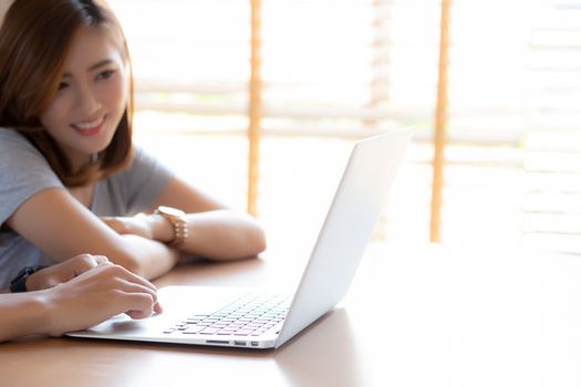 Asian young couple using laptop computer think and searching internet together, man and woman casual smiling work at home with happy and relax, communication and business concept.