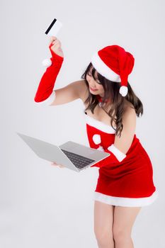 Beautiful portrait young asian woman in santa holding credit card and laptop computer for shopping online in Christmas holiday isolated on white background, asia girl purchase and pay to internet.