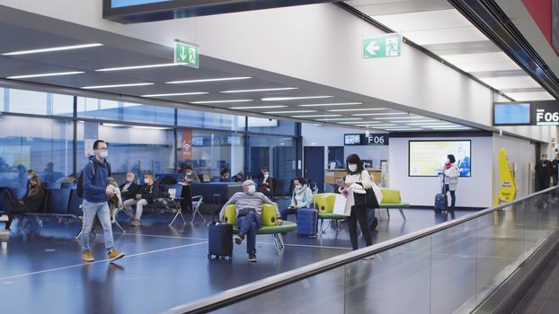 Vienna, Vienna/Austria - November 2nd 2020: Passengers walking to departure gates at Vienna airport. Only a few people travelling and a lot of closed gates.