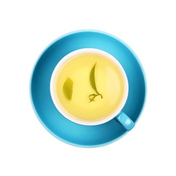 Close up one cup full of green oolong tea with leaf on blue saucer isolated on white background, elevated top view, directly above