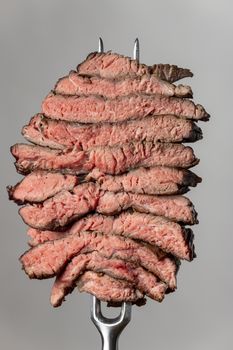 slices of a steak on grey background