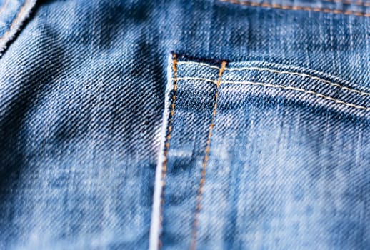 Detail of the denim fabric of a pair of jeans with the seam of the pocket.