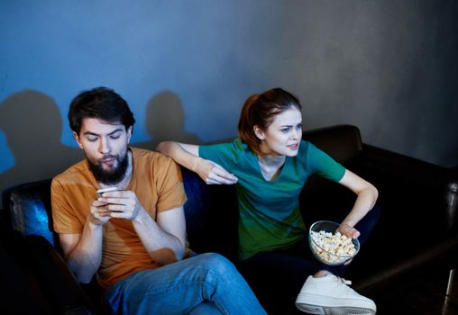 evening tv watching and a married couple with popcorn in a plate. High quality photo