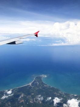 Wing of an airplane flying above the ocean 