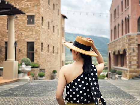 Woman wearing a planter panama hat visiting an Italian style village in summer