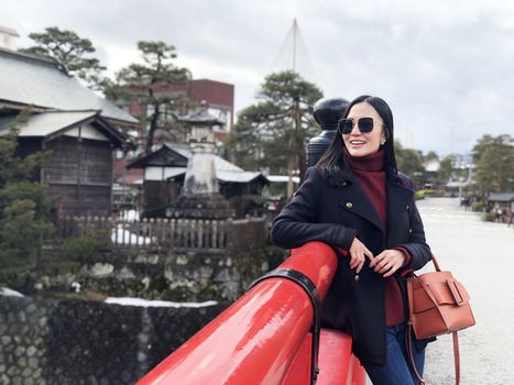 Happy woman tourist enjoy view in Red Nakabashi Bridge of Takayama, Japan