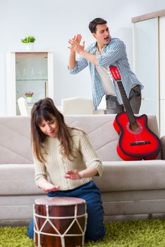 Young family singing and playing music at home