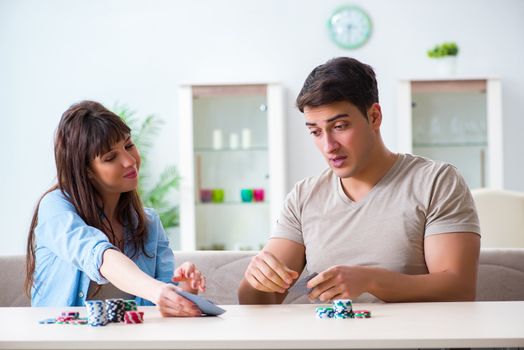 Young family playing cards at home