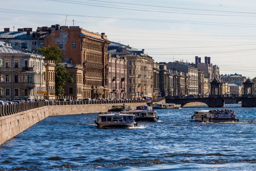 SAINT-PETERSBURG, RUSSIA - MAY,09 2014: Fontanka river with tourist boats full of people. Telephoto shot at daylight.