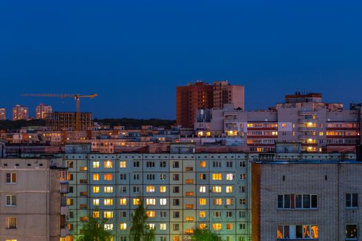 Windows, roofs and facade of an mass apartment buildings in Russia at evening