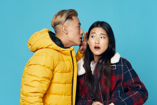 Young couple socializing fashionable clothes winter studio dating blue background