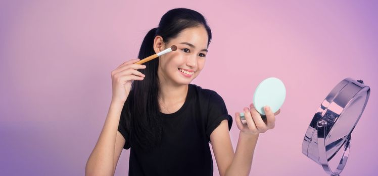 Asian teen woman sit in front of camera and live broadcasting as a beauty blogger influencer or youtuber to review or advice about how to make up at home. studio shot white background.