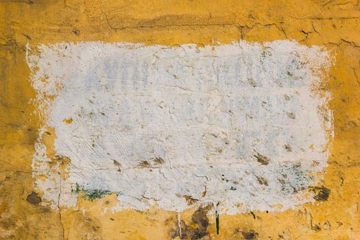 Yellow plsater wall with black mold background and white rectangular on it.