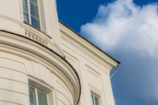 classicism style white house architecture fragment with blue sky and white cloud