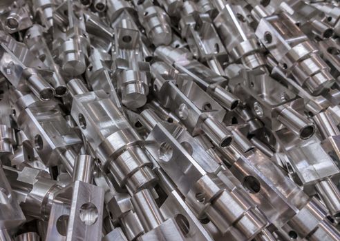 Shiny aluminium cnc machined parts background with selective focus close up technique.