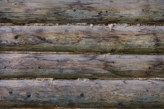 gray round log wall with linen gasket between beams