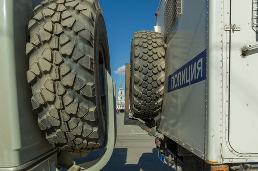 Two russian police trucks closing way to square, word on right truck means POLICE in russian