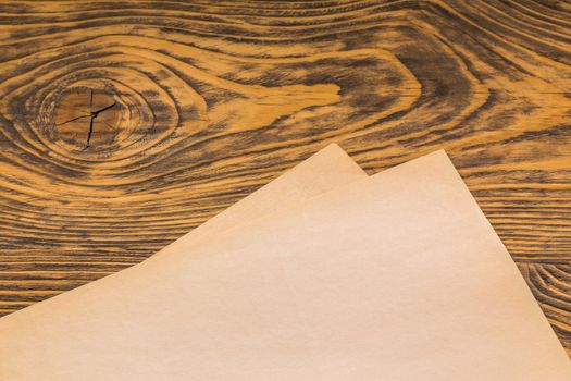 sheets of old yellow paper on wooden table surface with selective focus
