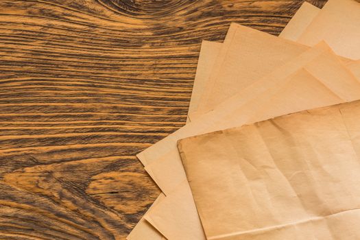 sheets of old yellow paper on wooden table surface