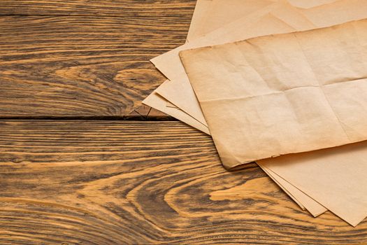 sheets of old yellow paper on wooden table surface