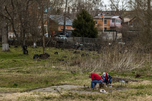 Two russian guys making barbecque in typical place with strong alcohol intoxication view with selective focus.