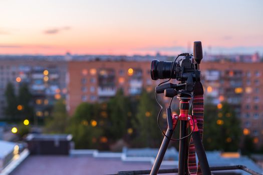 pro dslr on tripod in evening roof photoshoot with selective focus