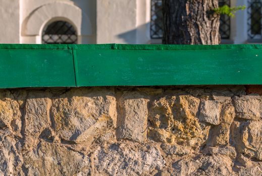 limestone fence with green metal top background with selective focus