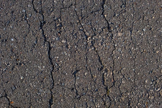 cracked across flat asphalt texture with hard direct sunlight