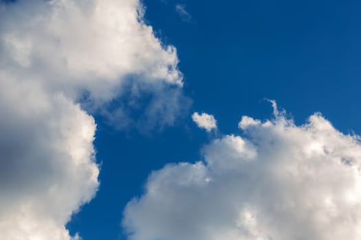 white clouds on blue sky background telephoto view