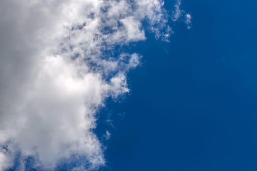 white c cumulus clouds on blue sky background telephoto view