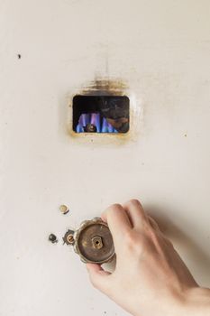 Hand adjusting old russian gas water heater with flat front panel