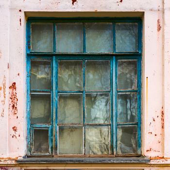 big old rectangular blue wooden window with peeling paint, view from outside