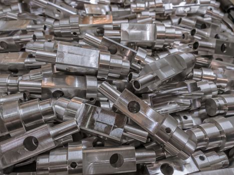 Shiny aluminium cnc machined parts background with selective focus close up technique.