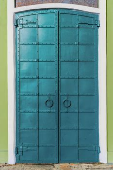 fresh painted old riveted iron double door with two rings