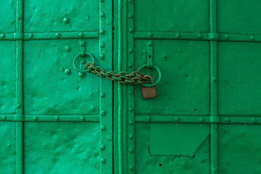 fresh painted old riveted iron double door with two rings