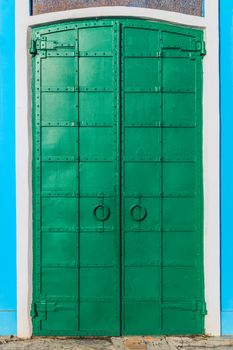 fresh painted old riveted iron double door with two rings