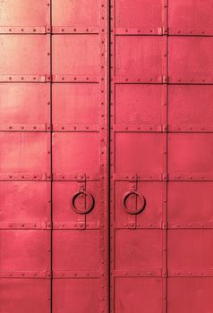fresh painted old riveted iron double door with two rings
