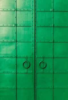 fresh painted old riveted iron double door with two rings