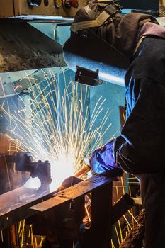 worker with protective mask welding metal