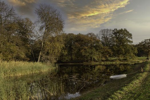 two boats in a pond in the autum forest with red brown and golden colors in national park de veluwe in holland