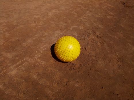 Yellow ball on the wet sand by the sea. Space for text.