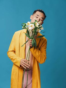 Romantic man with a bouquet of flowers on a blue background Asian model attractive appearance. High quality photo