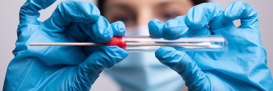 Medical healthcare nurse holding Coronavirus COVID-19 swab test kit, PPE protective mask and gloves, tube for taking OP NP patient specimen sample, PCR DNA RNA testing protocol process stock photo