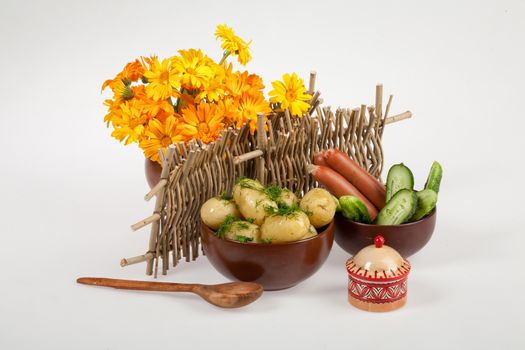 Potatoes, greenery and tableware on isolated satudio background