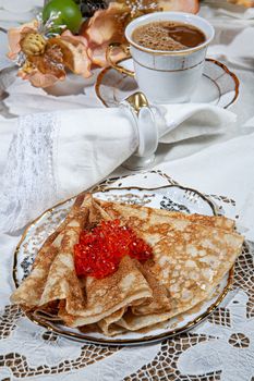 Pancakes and caviar on a canvas studio background