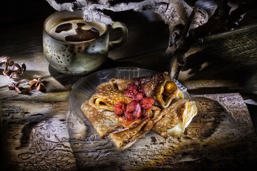 Pancakes and cup of coffee ona wooden desk