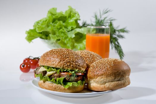 Hamburgers, greenery, tomatoes and juice