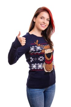 Beautiful smiling young girl in Christmas sweater showing thumb up gesture, isolated on white background. Christmas and New Year holiday concept.