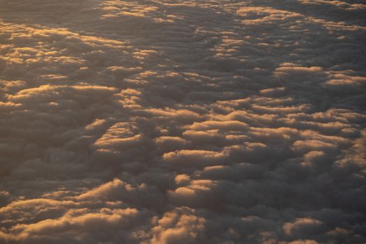 Dramatic sunset scenic. View of sunset above clouds from airplane window.