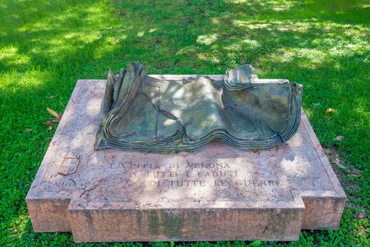 Verona, Veneto/Italy - 18.08.2020: A monument in the form of a book made of stone and metal commemorating the victims of all past wars and inscribed in Italian